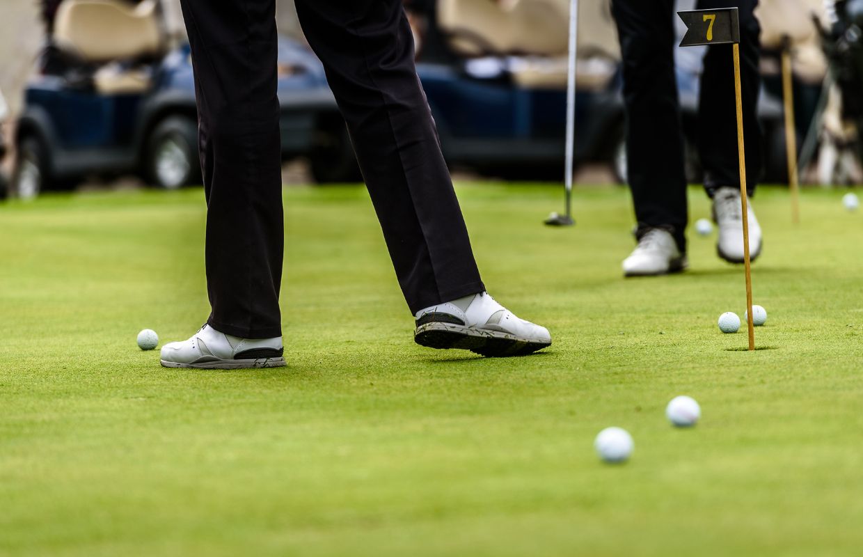Golfers standing on putting green
