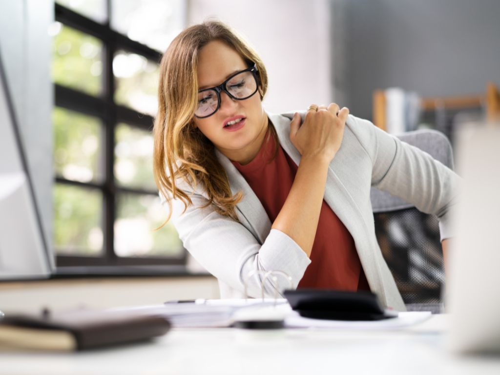 Woman sitting at desk experiencing neck pain