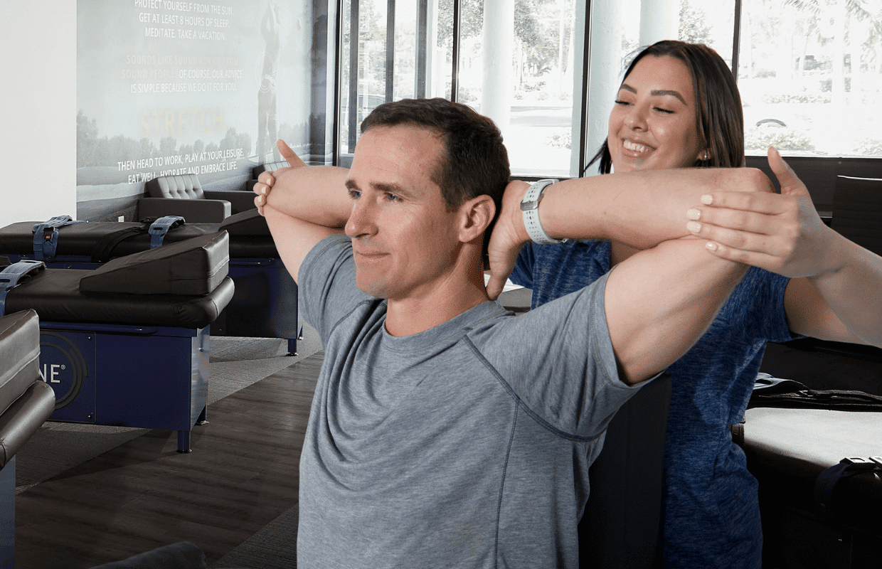 Experienced fitness trainer guiding a client through a personalized stretching routine at Stretch Zone studio