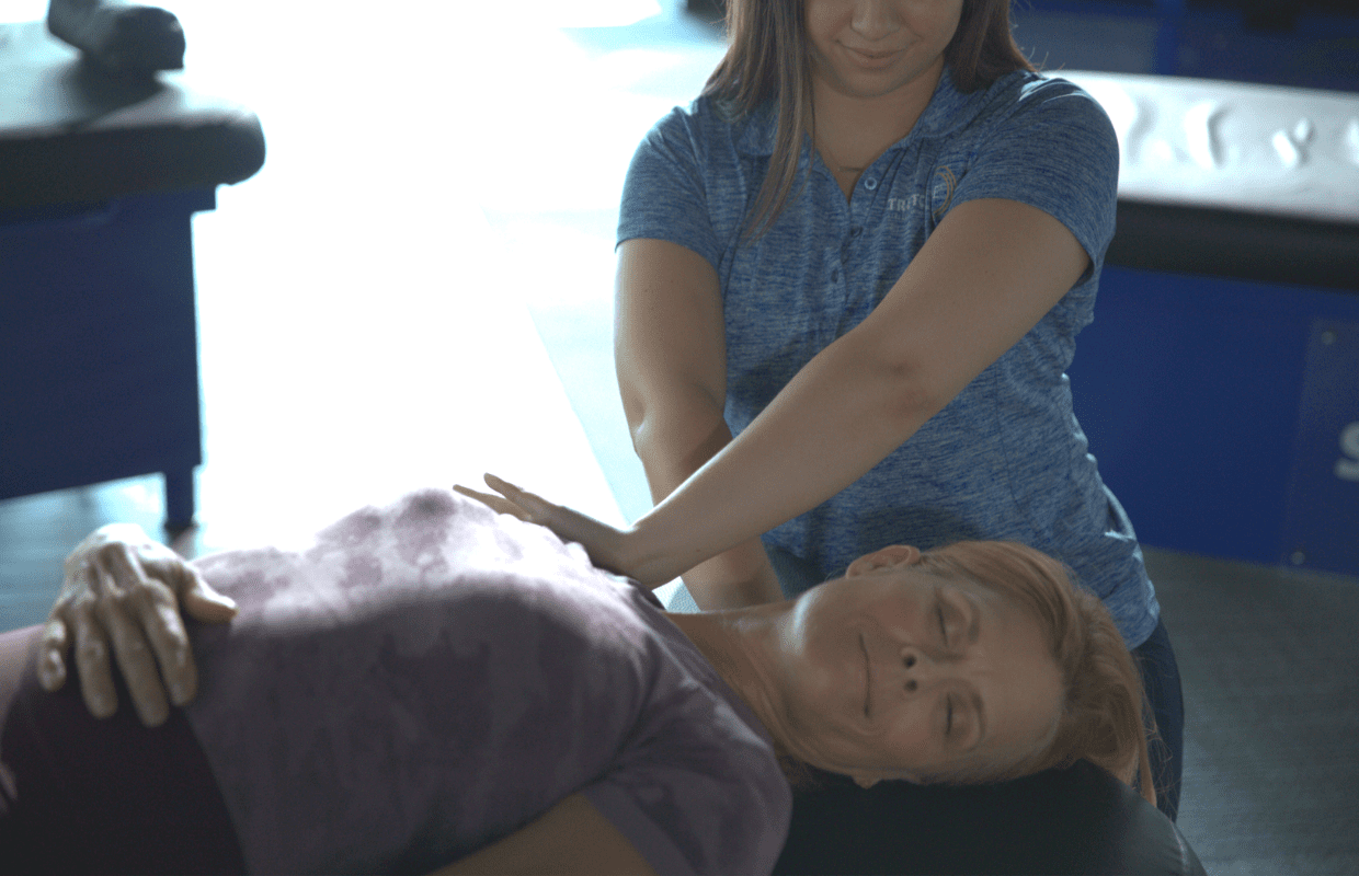 Experienced fitness trainer guiding a client through a personalized stretching routine at Stretch Zone studio