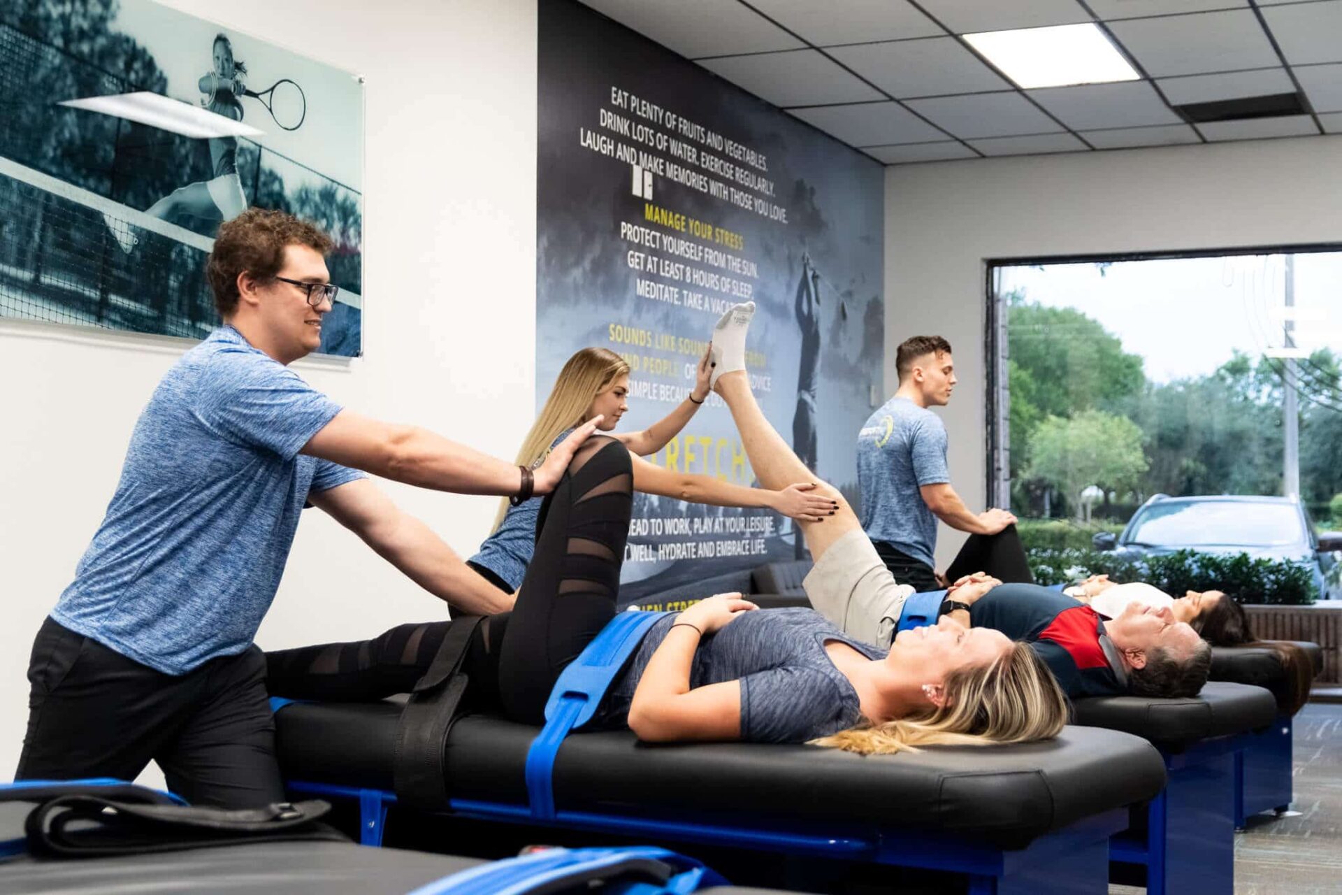 Experienced fitness trainer guiding a client through a personalized stretching routine at Stretch Zone studio