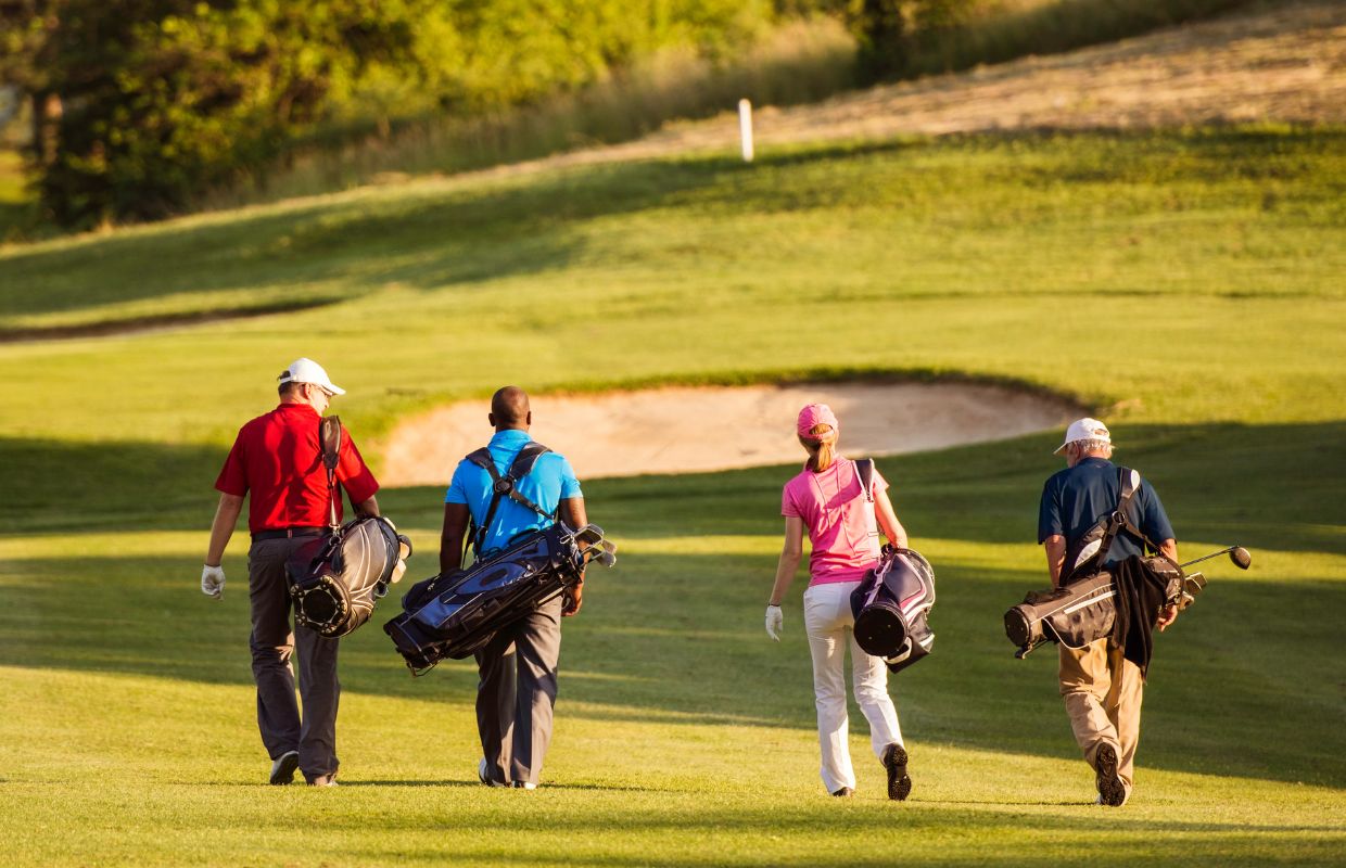 4 golfers walking on a golf course