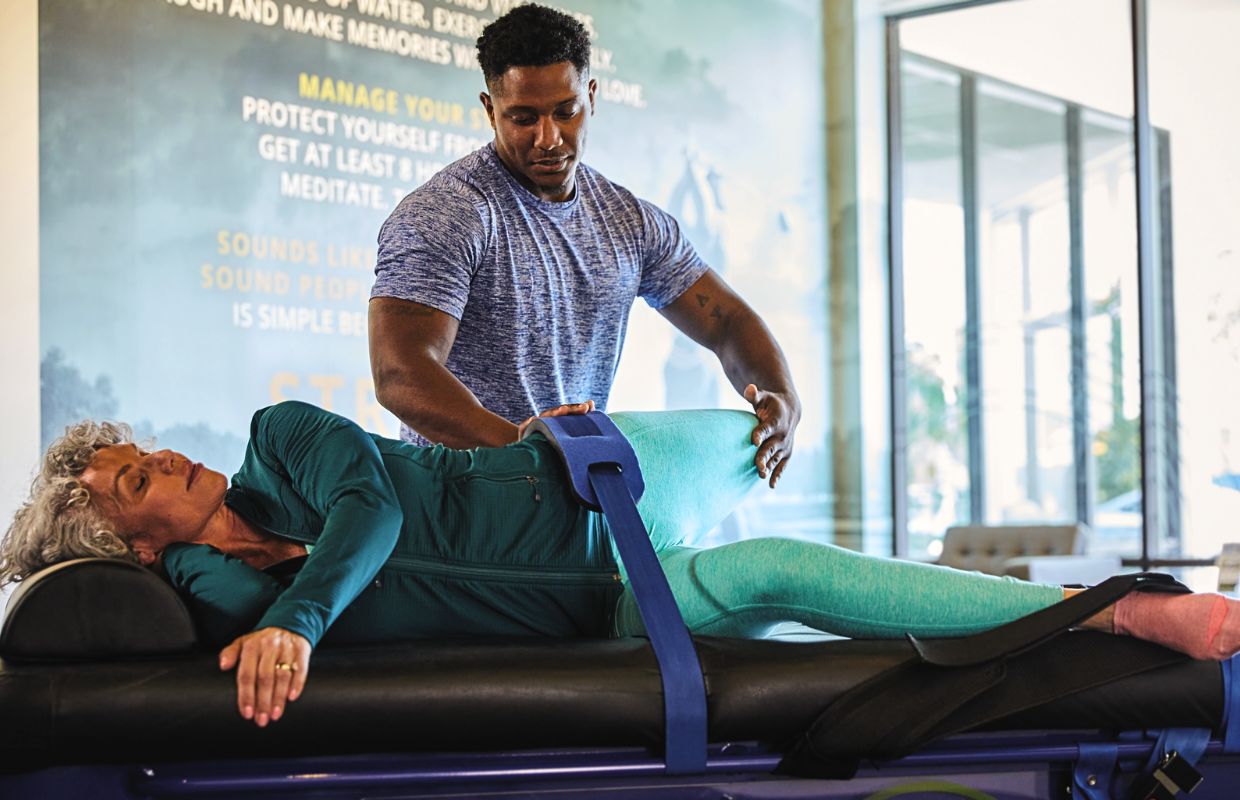 Stretch Practitioner performing a quadricep stretch on a client at a Stretch Zone studio.