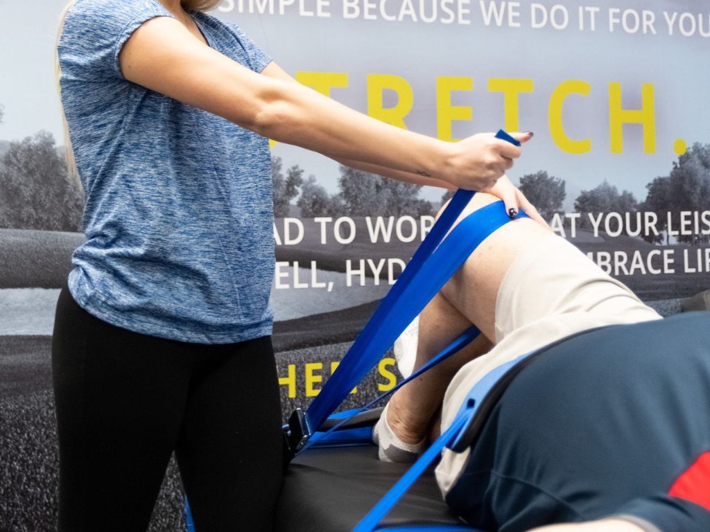 Stretch practitioner performing a leg stretch on a client at a Stretch Zone studio