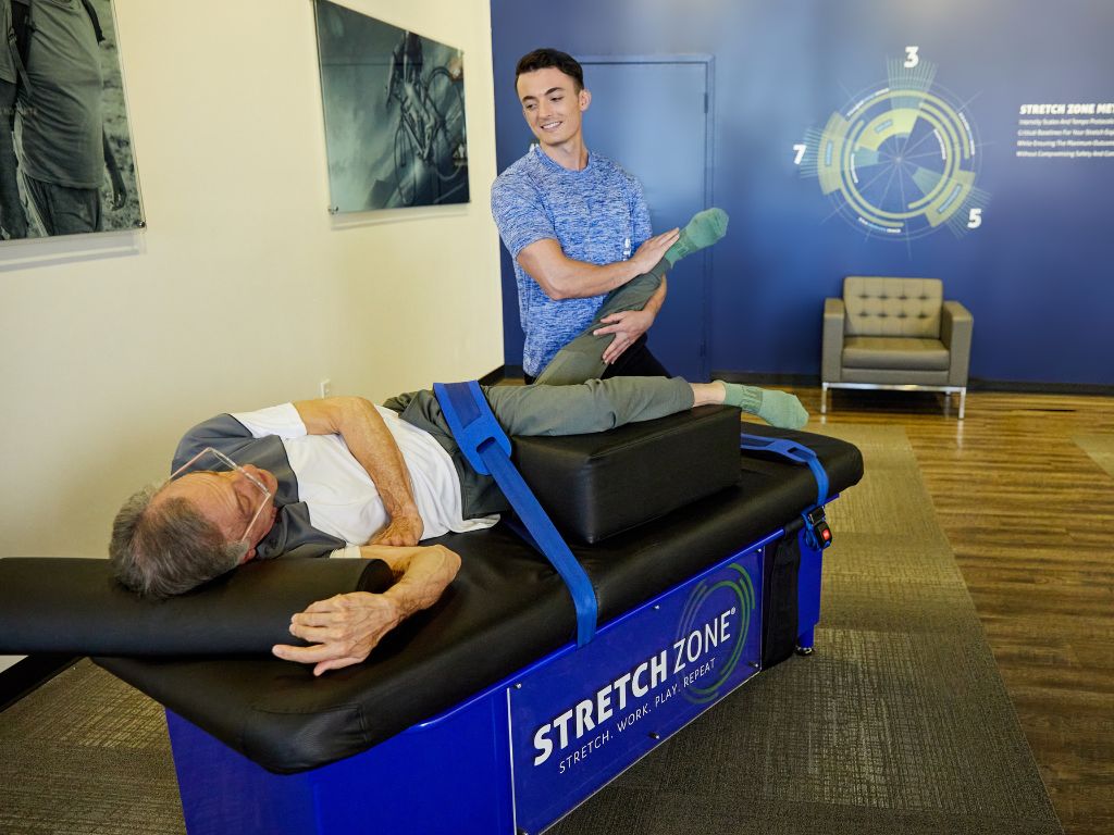 Practitioner performing a leg stretch on a client at a Stretch Zone studio