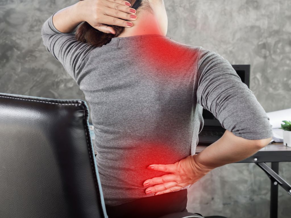 Woman experiencing lower back and neck pain